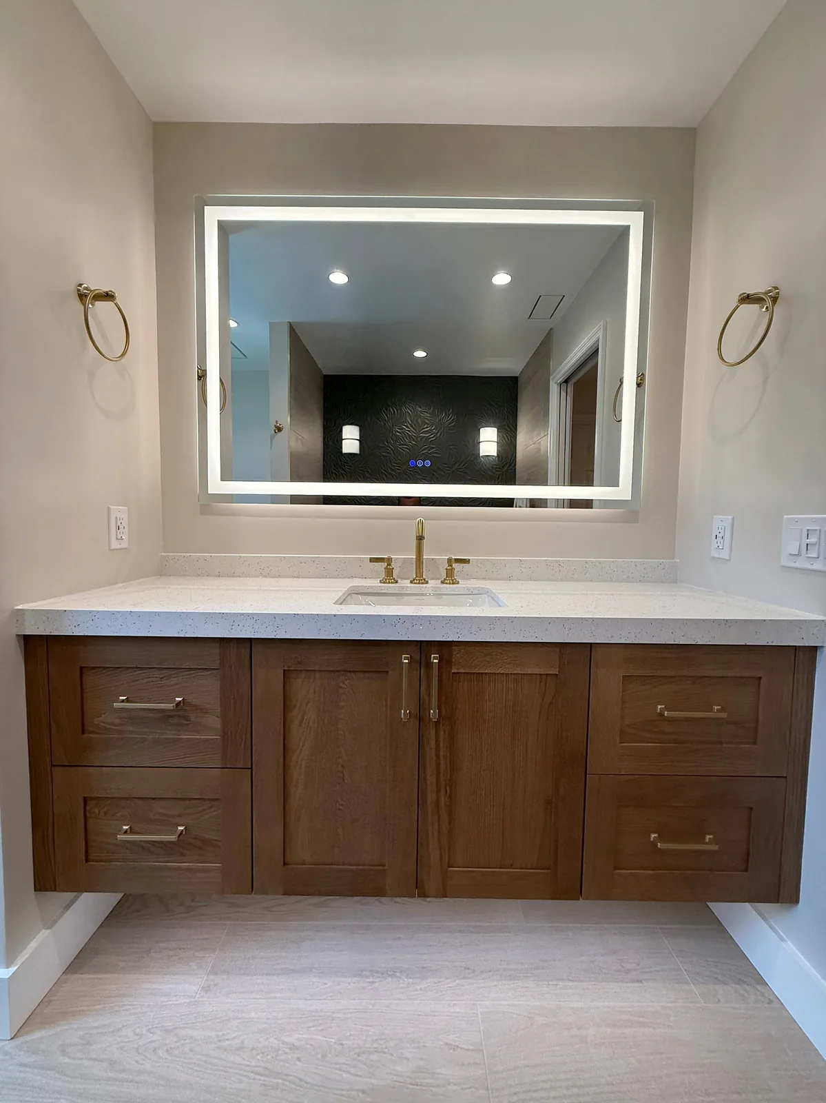 Bathroom remodel with an oak vanity, quartz top and LED mirror in Central Florida