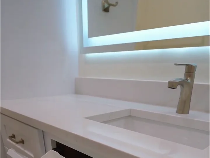 Bathroom vanity with a quartz countertop, undermount sink and backlit LED mirror in an Orlando, FL bathroom remodel