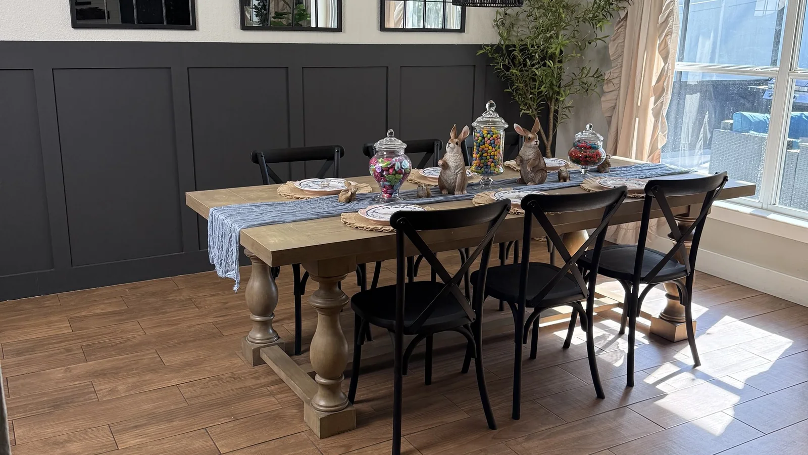 Dining room in a Winter Garden, FL home with wood-look tile floors, dark board-and-batten wainscoting and a farmhouse table