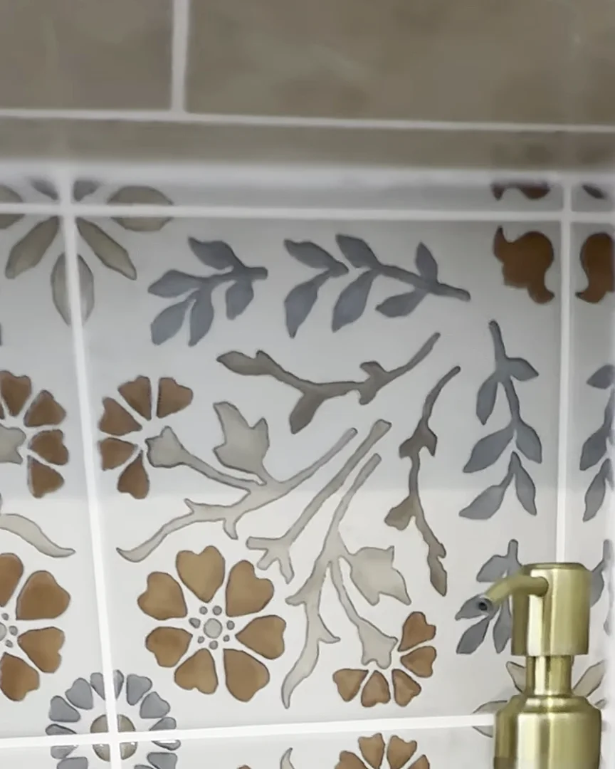 Shower niche with floral accent tile and a brass soap dispenser in a Dr. Phillips, Orlando bathroom remodel