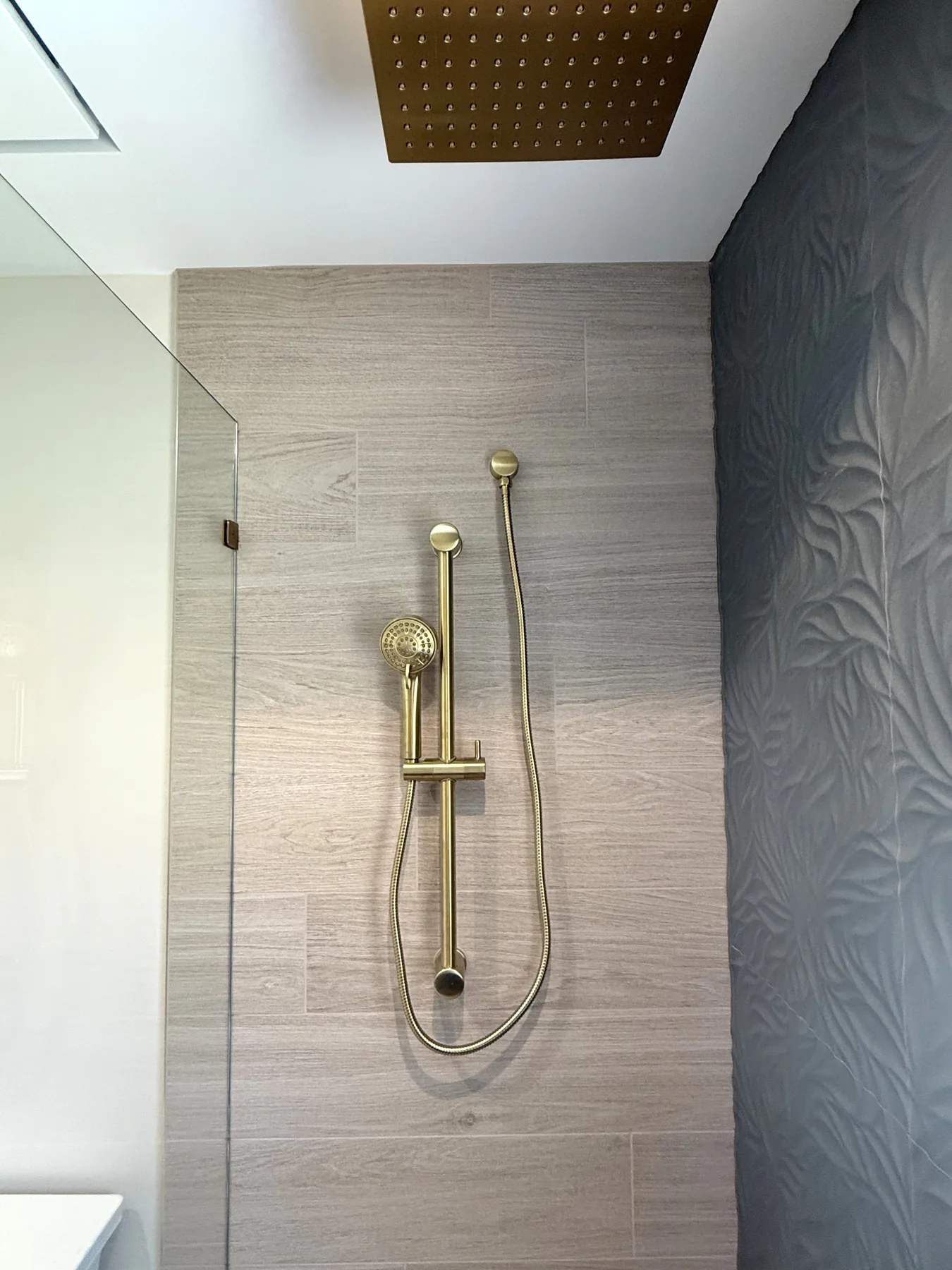 Bathroom remodel with a gold rain shower head and tiled shower niche in Central Florida