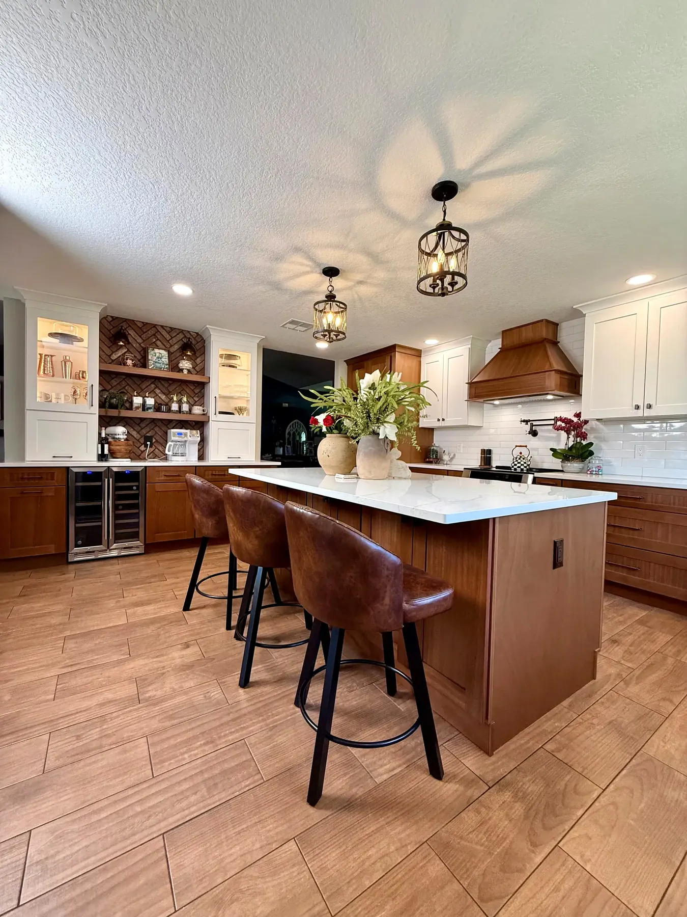 Kitchen island with seating for three and wood-look tile flooring in a Winter Garden, FL kitchen remodel