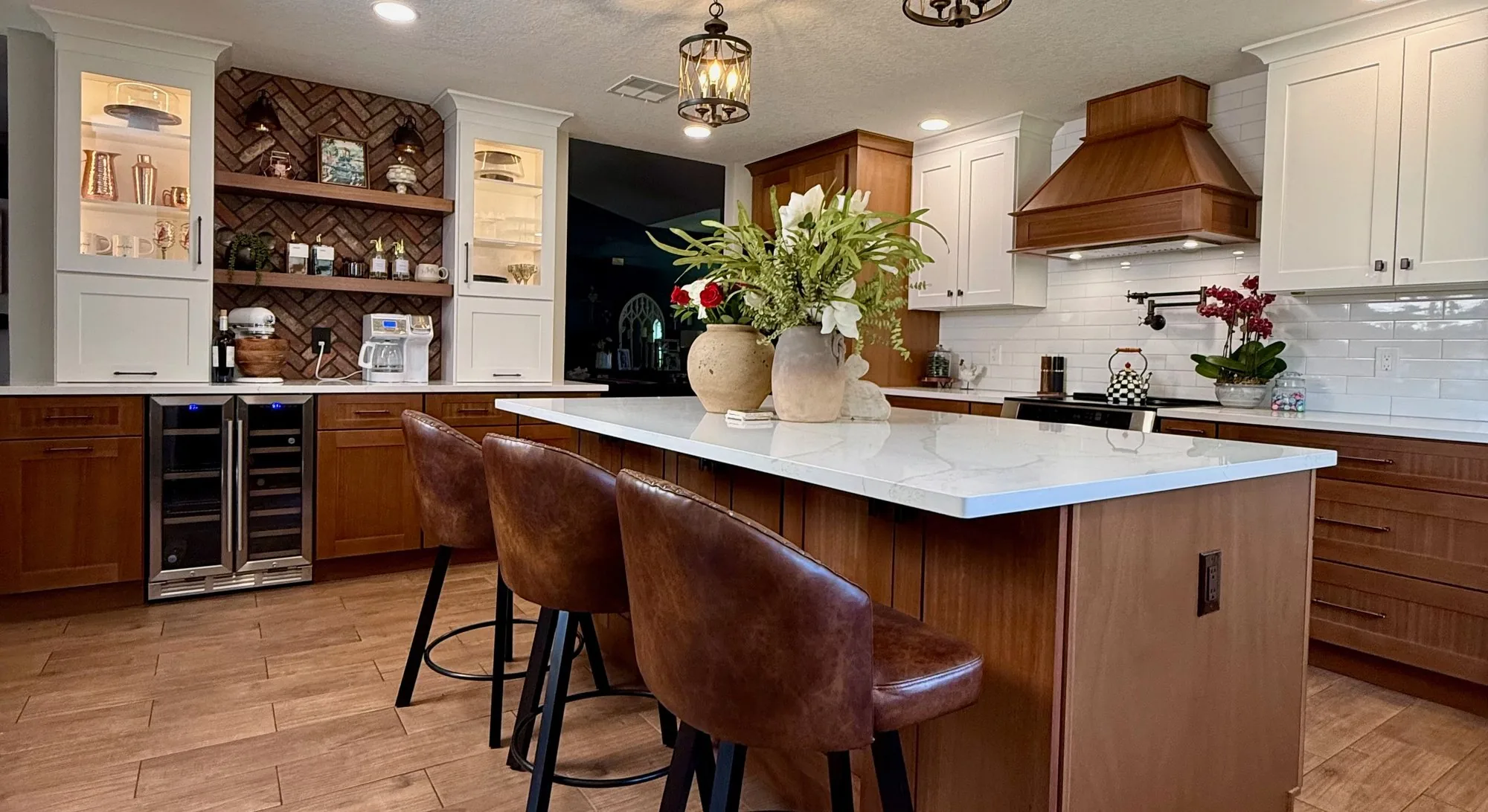 Remodeled kitchen in Winter Garden, FL with a quartz island, leather counter stools, wood cabinetry and lantern pendants