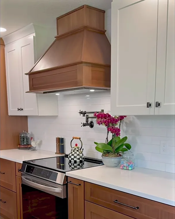 Custom wood range hood and wall-mounted pot filler above the range in a Winter Garden, FL kitchen remodel