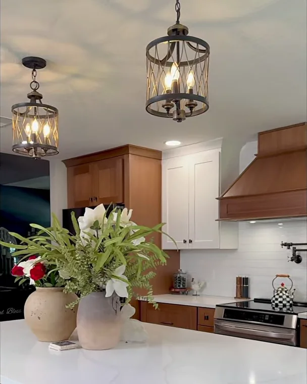 Winter Garden, FL kitchen remodel with lantern pendants over the quartz island, white and wood cabinetry and a custom wood range hood