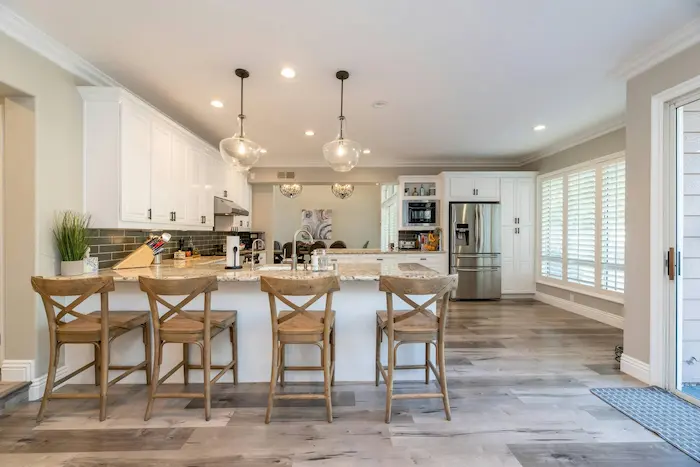 Modern white kitchen remodel with island seating and pendant lighting by Posada Remodeling & Design