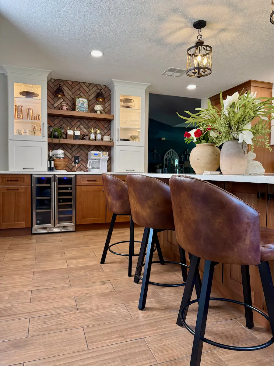 Custom kitchen remodel in Winter Park, FL with wood cabinetry, island seating, and brick backsplash