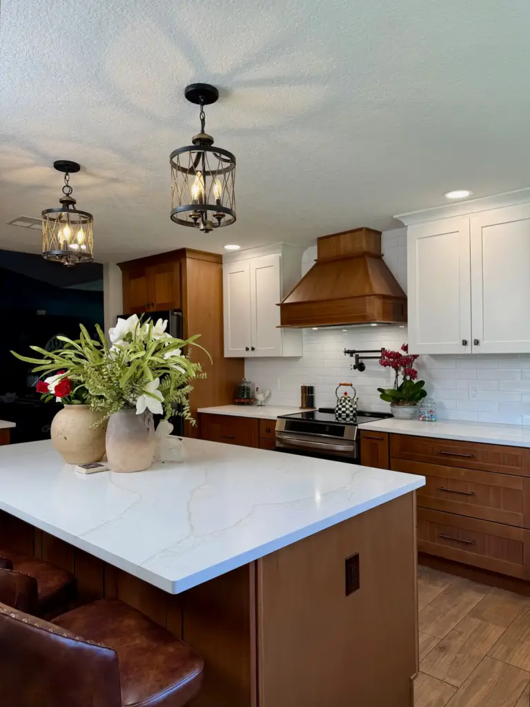 Custom kitchen remodel in Winter Park, FL with wood cabinetry, white quartz island, and matching wood range hood