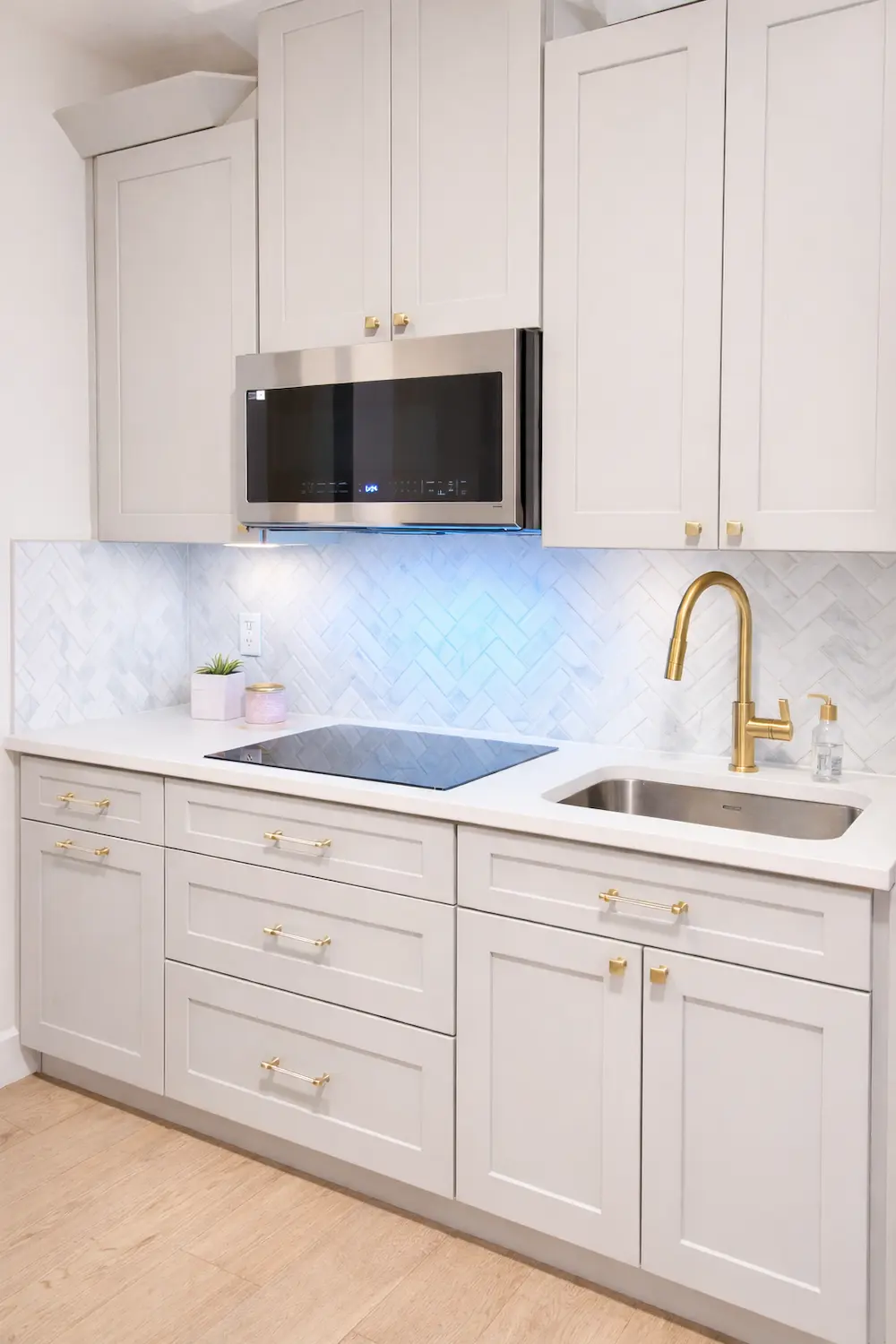 Davenport kitchen remodel with white cabinets, gold fixtures, herringbone backsplash, and updated appliances