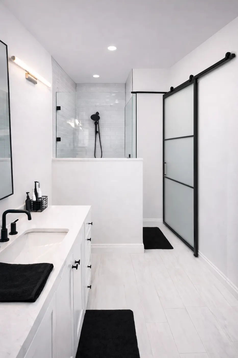 Modern bathroom remodel in Baldwin Park FL with black fixtures and frameless glass shower